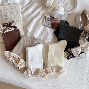 Flat lay of colorful cotton socks with delicate lace edges and cute bow accents
