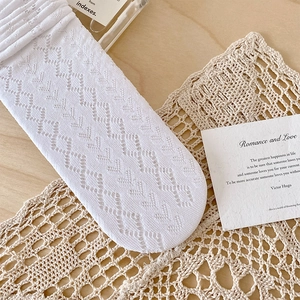 Detailed macro view of white diamond mesh knit pattern on lace-trimmed calf socks