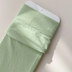 Detailed view of mint green knit crew socks with high-quality ribbed cuff texture