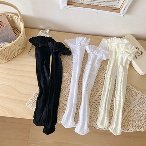Détails de chaussettes en dentelle ajourée avec nœuds décoratifs en noir et blanc