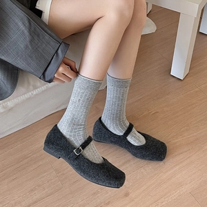 Close-up of gray striped crew socks paired with vintage wool Mary Jane shoes