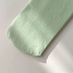 Close-up of soft candy green velvet knit socks with delicate texture and round toe detail