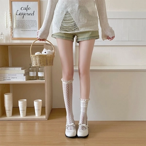 Detail of white lace socks with red heart patterns and ruffles with Mary Jane shoes