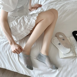 Detail of breathable mesh low-cut socks with elegant bow embroidery and anti-slip silicone
