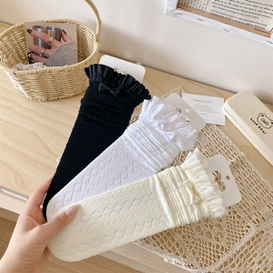 Trois paires de chaussettes en dentelle ajourée avec nœuds en noir, blanc et beige