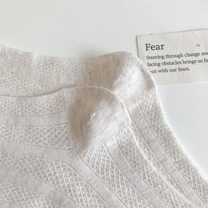 Vue détaillée de chaussettes en coton beige à maille filet avec texture tricotée respirante