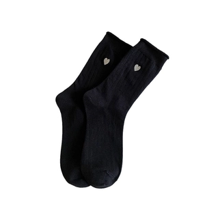Black vertical ribbed crew socks with white heart embroidery on a clean white background