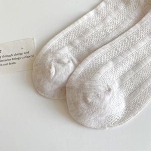 Gros plan de chaussettes blanches respirantes en maille avec rayures et détails ajourés