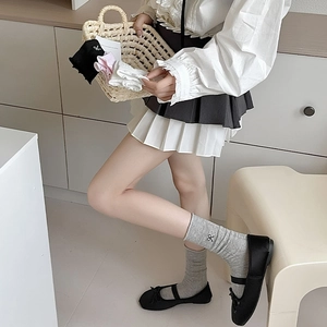 Detailed view of ballet style mid-calf socks with bow embroidery and ribbed cotton texture