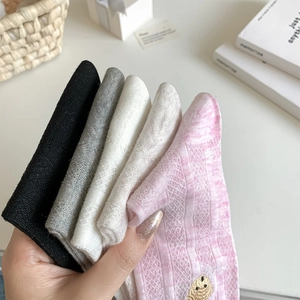 Détail de broderie d'ours sur chaussettes en coton rose avec bordure dentelle