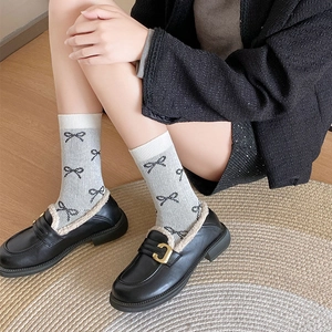 Socken im Ballett-Stil mit Schleife, kombiniert mit schwarzen Loafers und Plüschrand