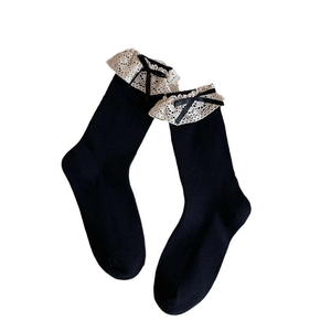 Japanese style black cotton mid-calf socks with white lace trim and satin bow accents