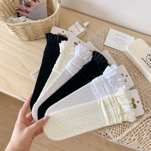 Trois paires de chaussettes en dentelle avec nœud et volants en noir, blanc et beige