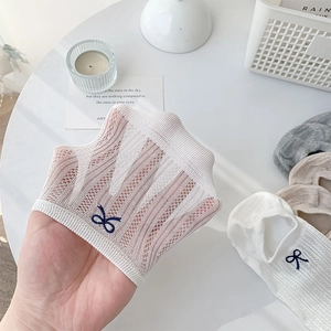 Close-up of breathable mesh ankle socks with delicate navy blue bow embroidery detail