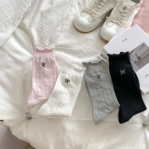 Detail of ruffled cuffs with black bow embroidery on breathable mesh crew socks