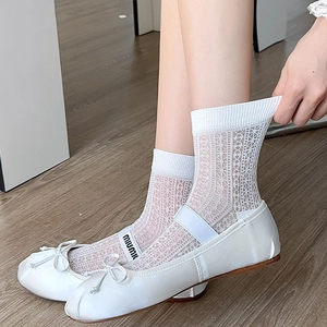 Dettaglio di ballerine in raso bianco con fiocco e cinturino elastico con logo ai piedi