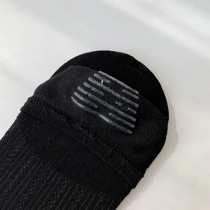 Close-up of black low-cut socks showing grey striped silicone non-slip heel grips