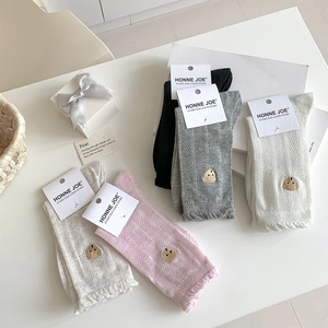 Détail de cinq paires de chaussettes en coton avec broderie ours et bordures ondulées