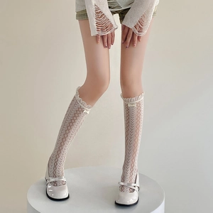 Détail de chaussettes blanches en résille avec dentelle et nœud avec des Mary Janes