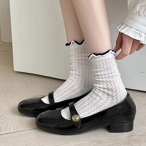 Close-up of Mary Jane shoes with white lace mesh socks featuring black ruffled edges