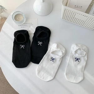 Detail of white and black low cut invisible socks with bows in a cozy lifestyle setting