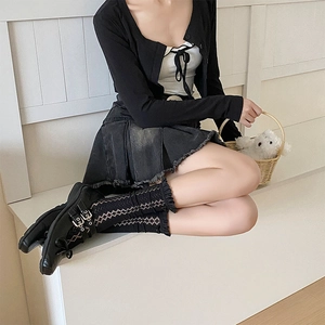 Détail de chaussettes en dentelle noire avec jupe plissée en denim gris foncé et souliers