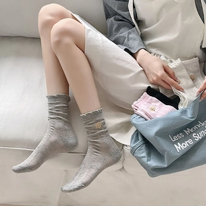 Gros plan de la broderie animale et du bord à volants sur chaussettes en maille
