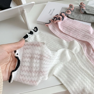 Detail view of breathable mesh socks with ruffled trim in white, pink, and grey colors