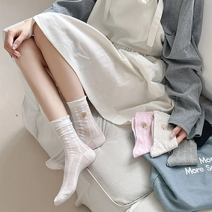Détail de chaussettes en maille avec bords à volants et broderie d'ours mignonne