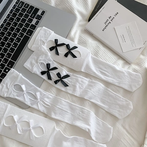 Flat lay of white Lolita socks with ribbon bows and breathable knit texture