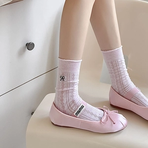 Detail of lavender diamond mesh socks with black bow embroidery and pink satin ballet flats