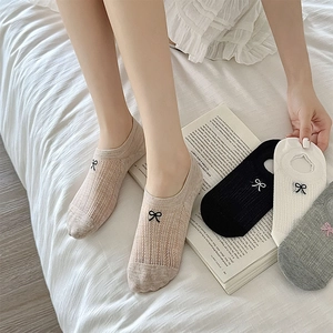 Close-up of low-cut mesh boat socks featuring bow embroidery and breathable texture
