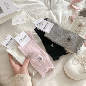 Close-up of ballet style bow embroidery and ruffled cuffs on breathable mesh mid-calf socks