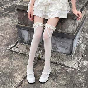 Détail de chaussettes hautes blanches avec bordure en dentelle et nœuds en soie