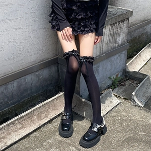 Vue détaillée des chaussettes hautes noires avec dentelle et nœud en ruban