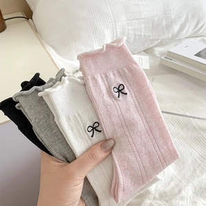 Detail view of cotton blend socks with argyle pattern, lace trim and bow embroidery