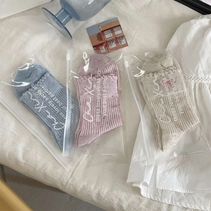 Detailansicht bunter Stricksocken in Blau und Rosa mit verspieltem Rüschensaum