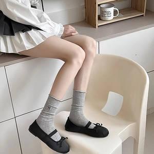 Detail of sweet ballet style socks with black bow embroidery paired with Mary Janes