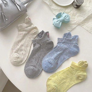 Détail de quatre paires de chaussettes courtes avec broderie nœud en tons pastel