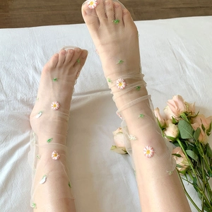 Detailed close-up of daisy embroidery on ultra-thin mesh sheer socks for women