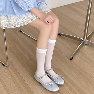 Detail of girls silver satin Mary Jane shoes with rhinestone strap and white socks