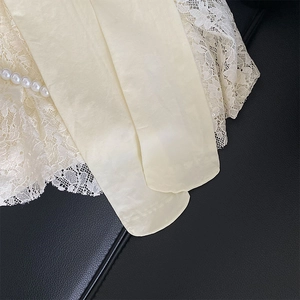 Détail de chaussettes hautes blanc crème avec bordure en dentelle blanche et perles décoratives