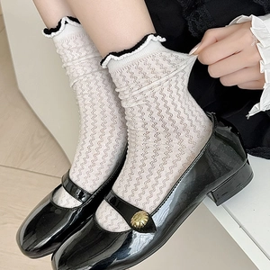 Close-up of white mesh socks with black wavy trim showing high elasticity and texture
