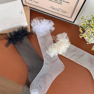 Lace ruffle trim on fishnet thigh-high stockings in black, white, and beige colors