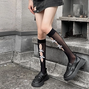 Detail of black mesh Lolita calf socks with white silk bows and cutout design