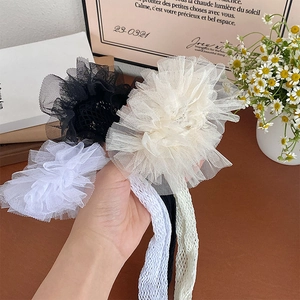 Detailed close-up of fluffy layered floral mesh hair scrunchies in neutral colors