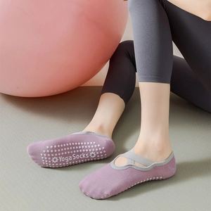 Close-up of purple yoga socks featuring non-slip silicone grips and crisscross straps