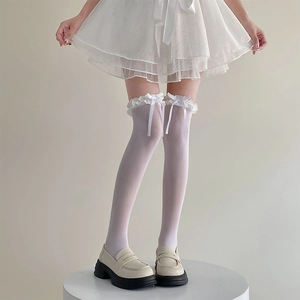 Détail de chaussettes hautes blanches avec volants en dentelle et nœuds décoratifs