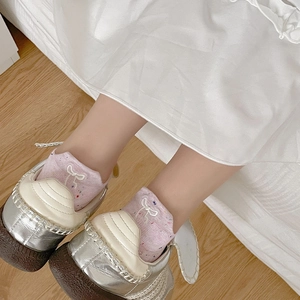 Gros plan de chaussettes roses en tricot avec broderie nœud et baskets rétro chic