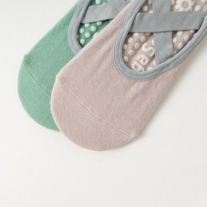 Close-up of silicone anti-slip dots and crisscross elastic straps on yoga socks